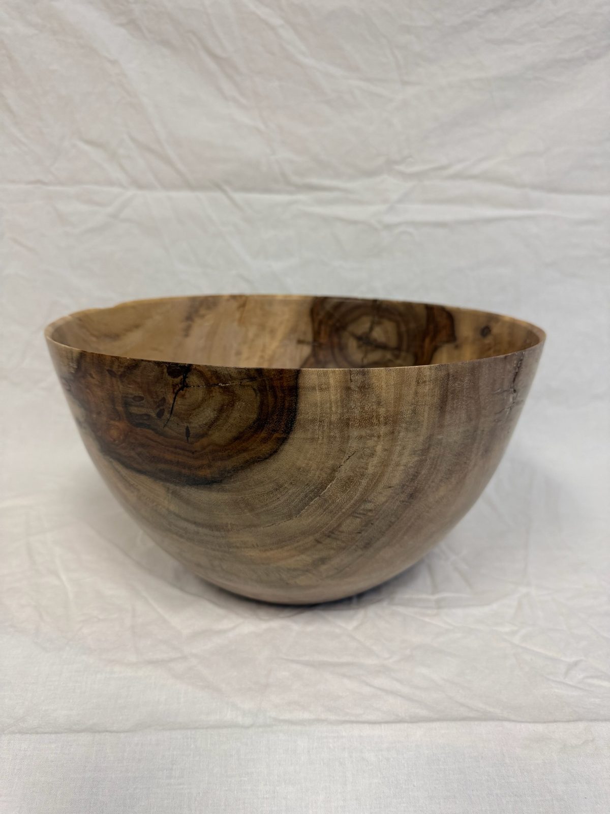 Hand-turned bowl in blonde wood with a reddish burl swirl