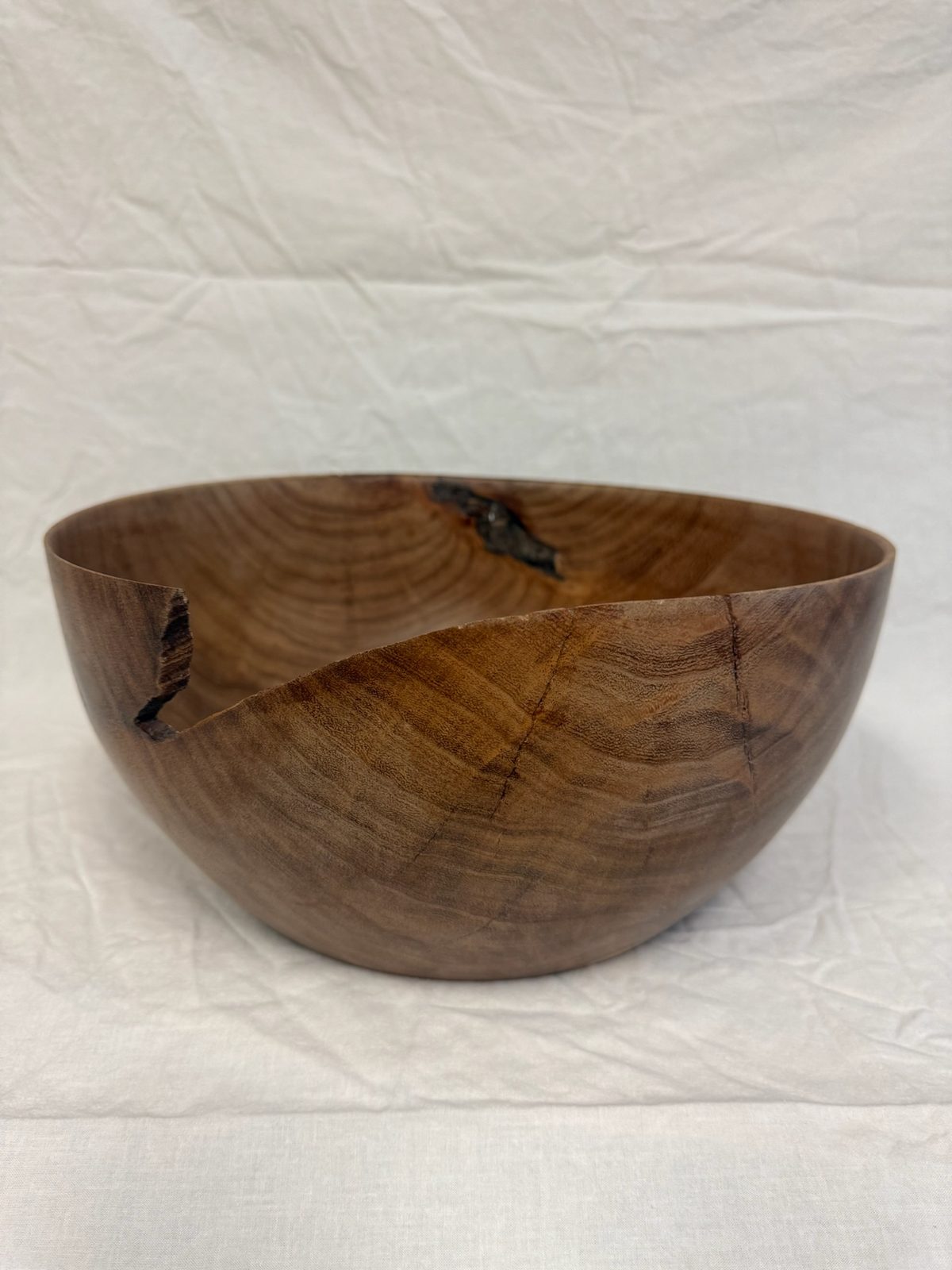 Hand-turned bowl with a natural bark-inclusion notch at the rim