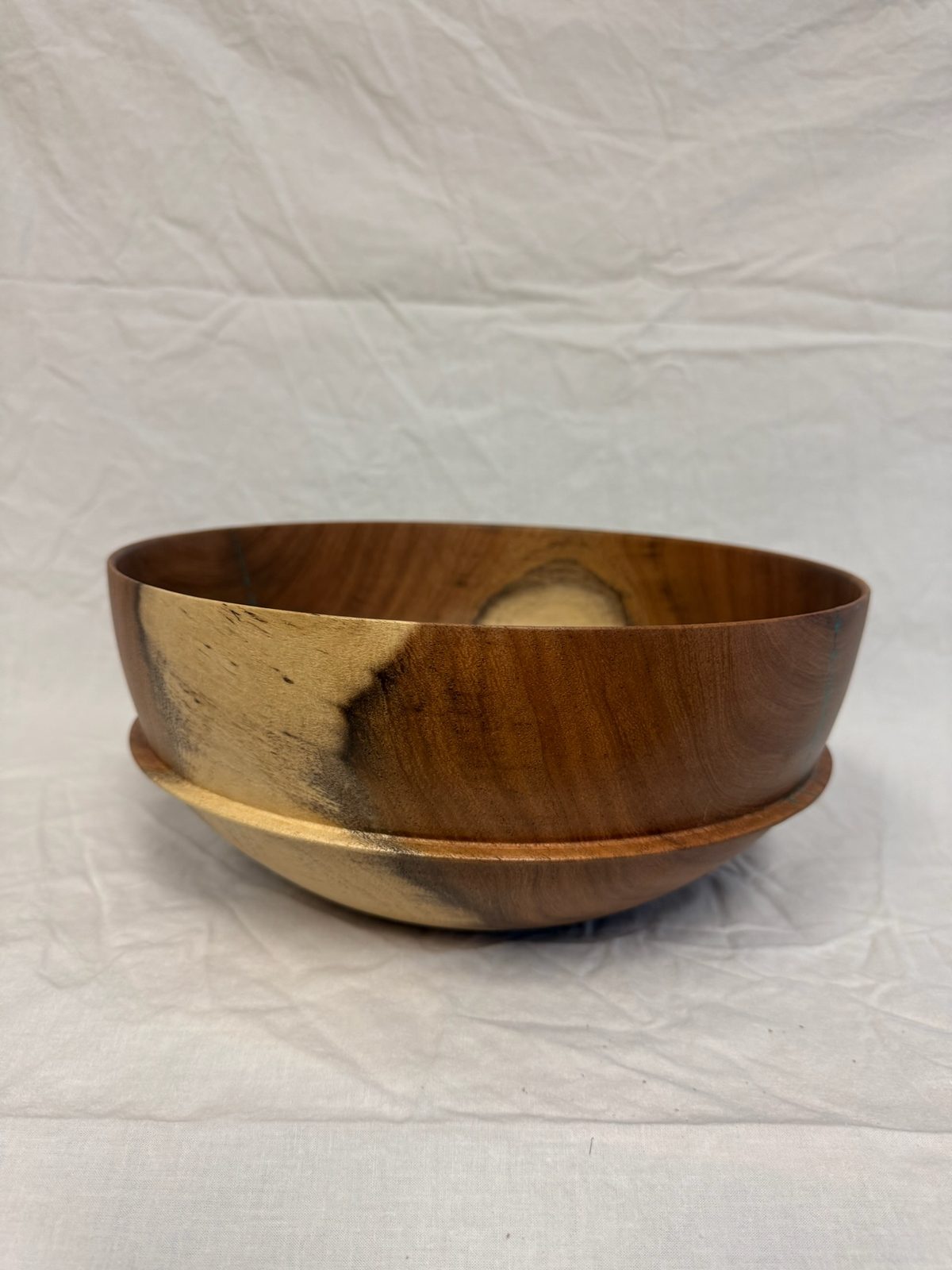 Hand-turned bowl on a footed base, in warm reddish-brown wood