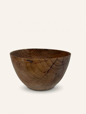 Hand-turned bowl in warm brown wood with a natural bark-inclusion mark